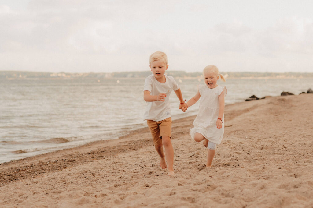 familienshooting ostsee strand, zwei kinder laufen am strand
