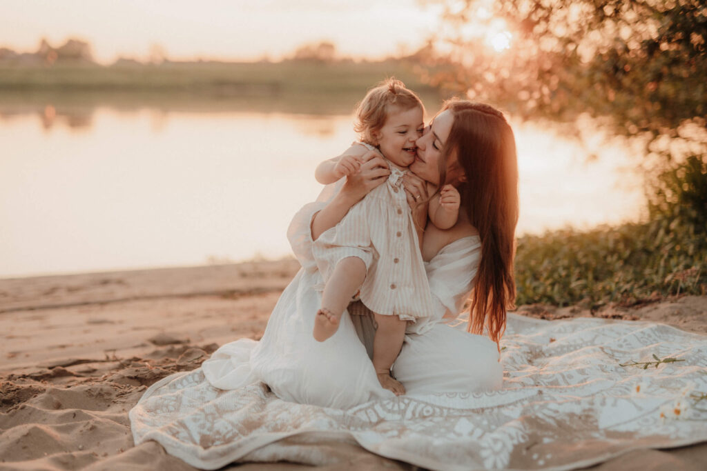 mama kind shooting, beide albern herum und haben spass am strand