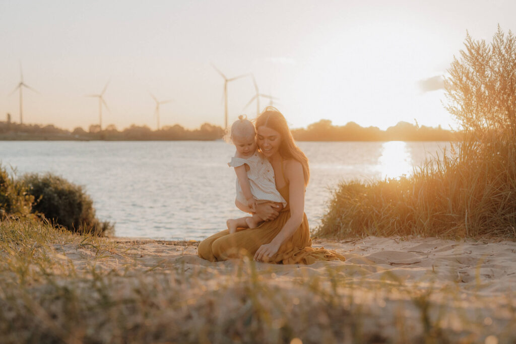 mama kind shooting, mama und kind sitzen am strand in drage im sand und gucken sich den sand an