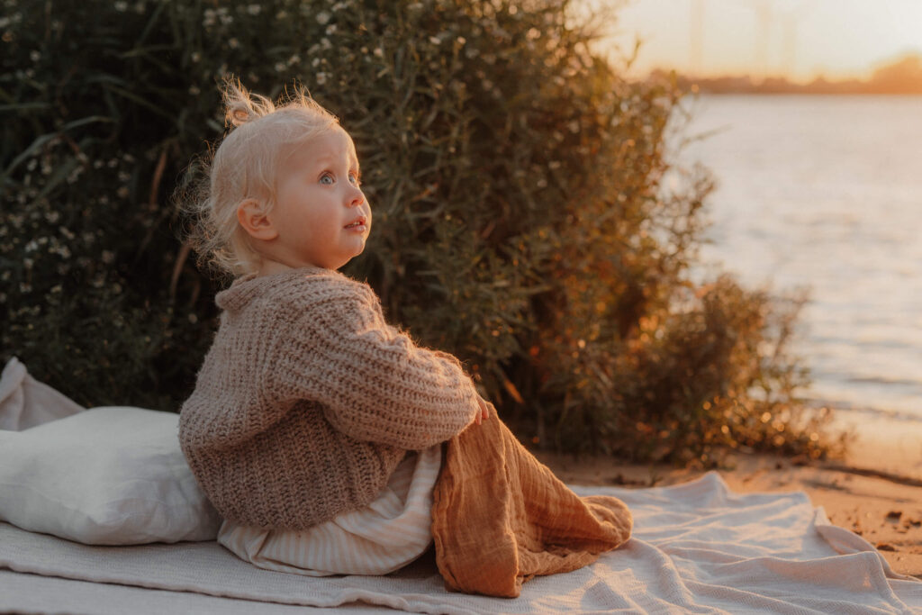 mama kind shooting, kind sitzt auf decke und guckt interessiert in den himmel